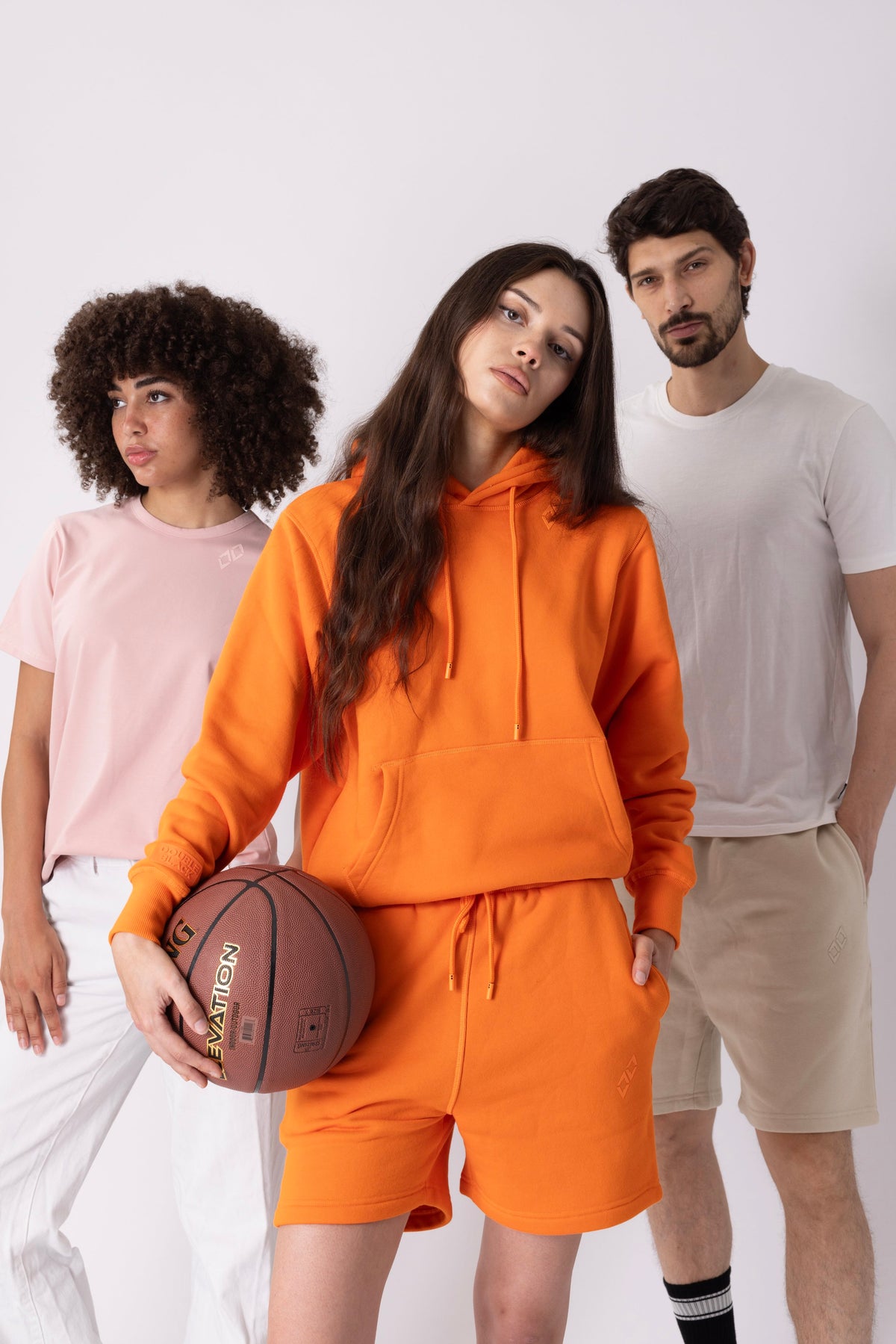 Models wearing Double Black Experts Only Sweatshorts in Orange and Cream