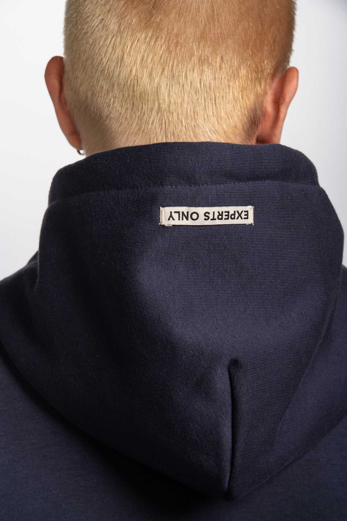 Model wearing Double Black Hoodie in navy and pink experts only hood label