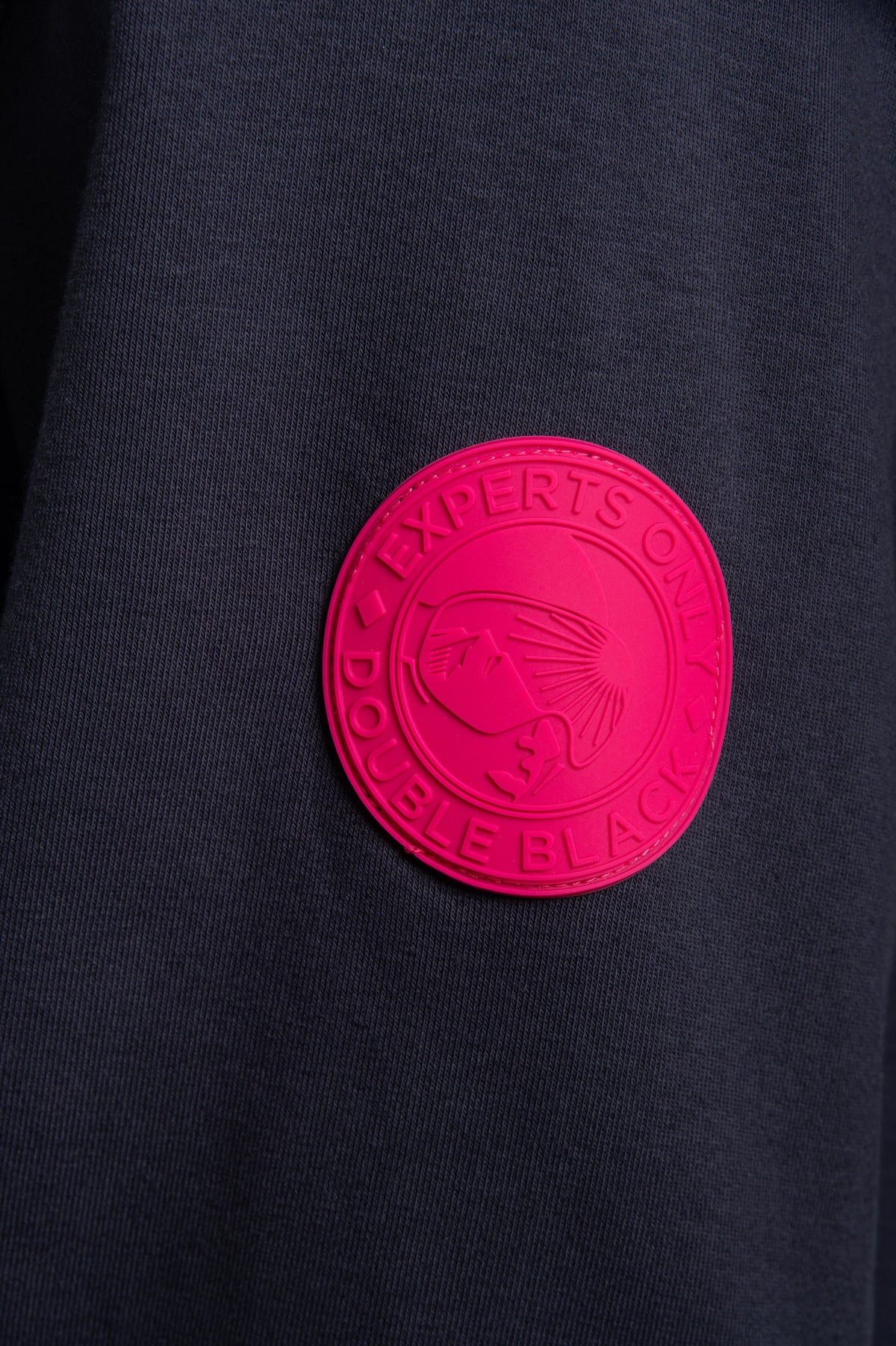 Model wearing Double Black Hoodie in navy and pink sleeve patch
