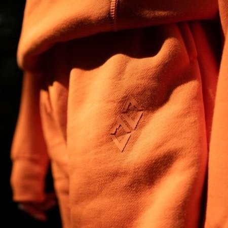 Model wearing Double Black Experts Only Sweatshorts in Orange