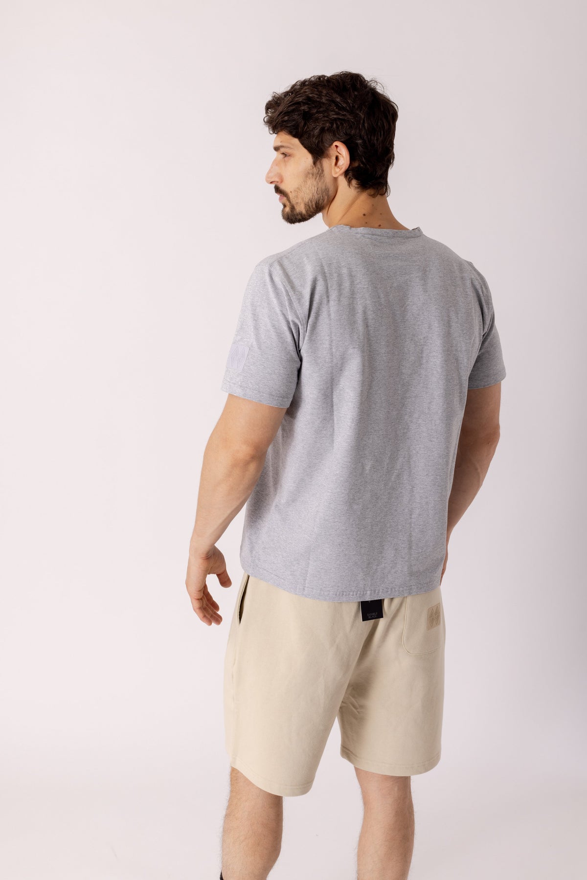 Model wearing Double Black Experts Only Sweatshorts in cream
