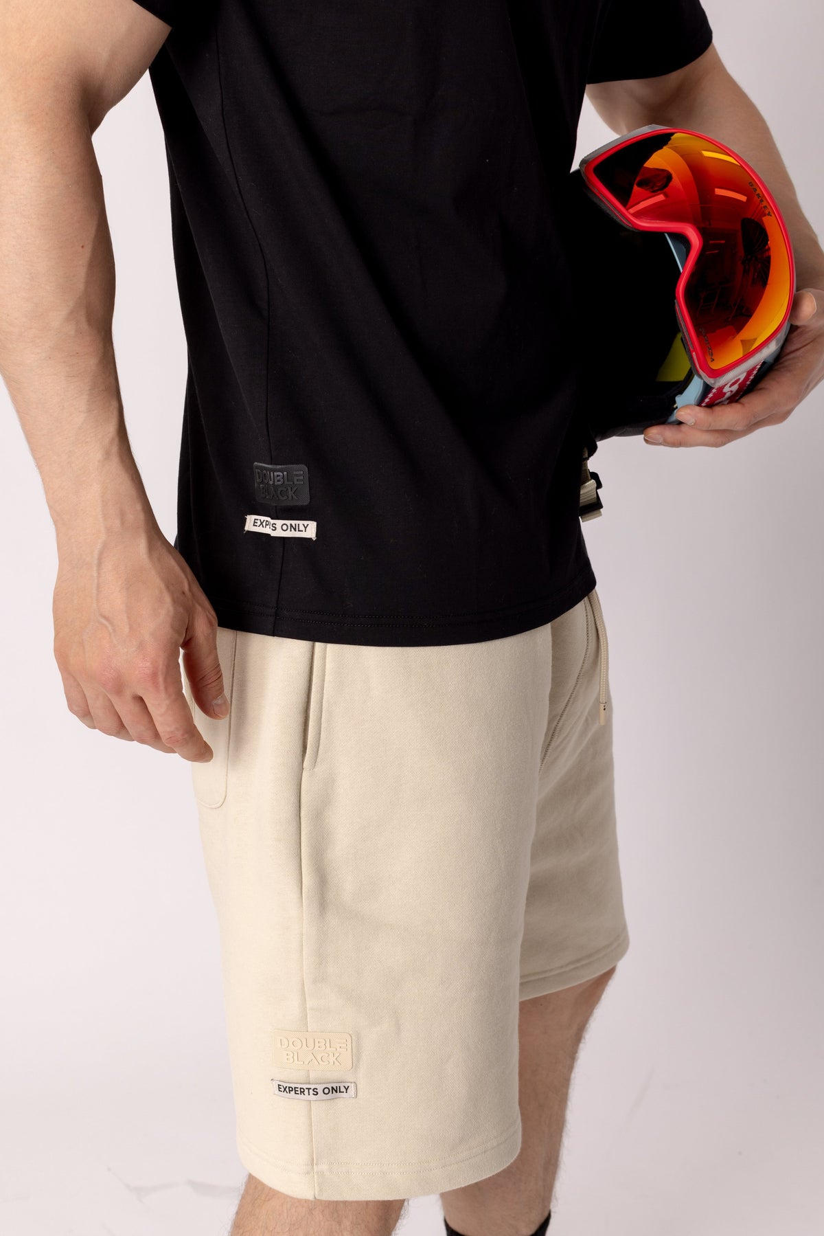 Model wearing Double Black Experts Only Sweatshorts in cream